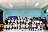 Mahasiswa Untirta dan siswa kelas 6A MIN 3 Serang berfoto bersama di sela kunjungan literasi l Dok. Istimewa